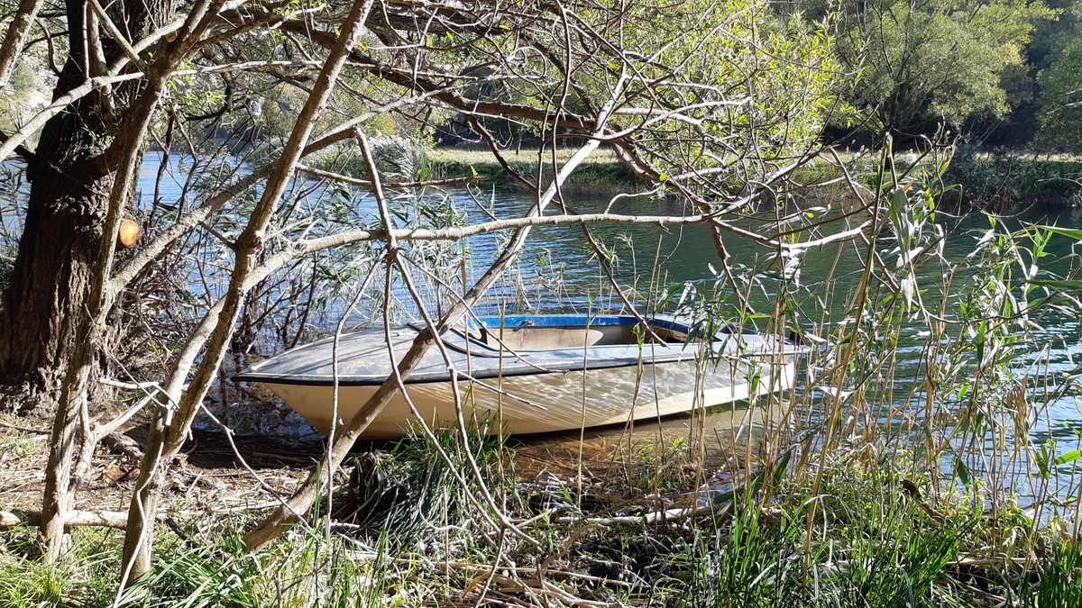 Een bootje ligt in de rivier Krupa.