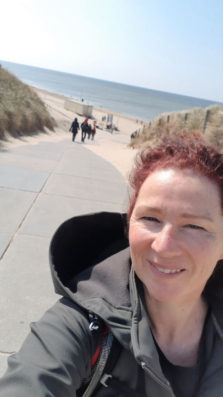 Wandelvrouw bij strandopgang Zee van Tijd Julianadorp