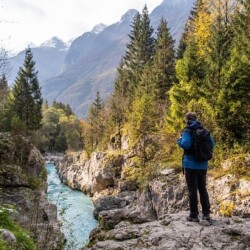 wandelvakantie Slovenie Senior Man admiring the Soca Valley Gorges, Slovenia, Julian Alps, Europe.