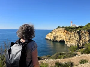 Algarve rotskust vuurtoren wandelaar met rugzak