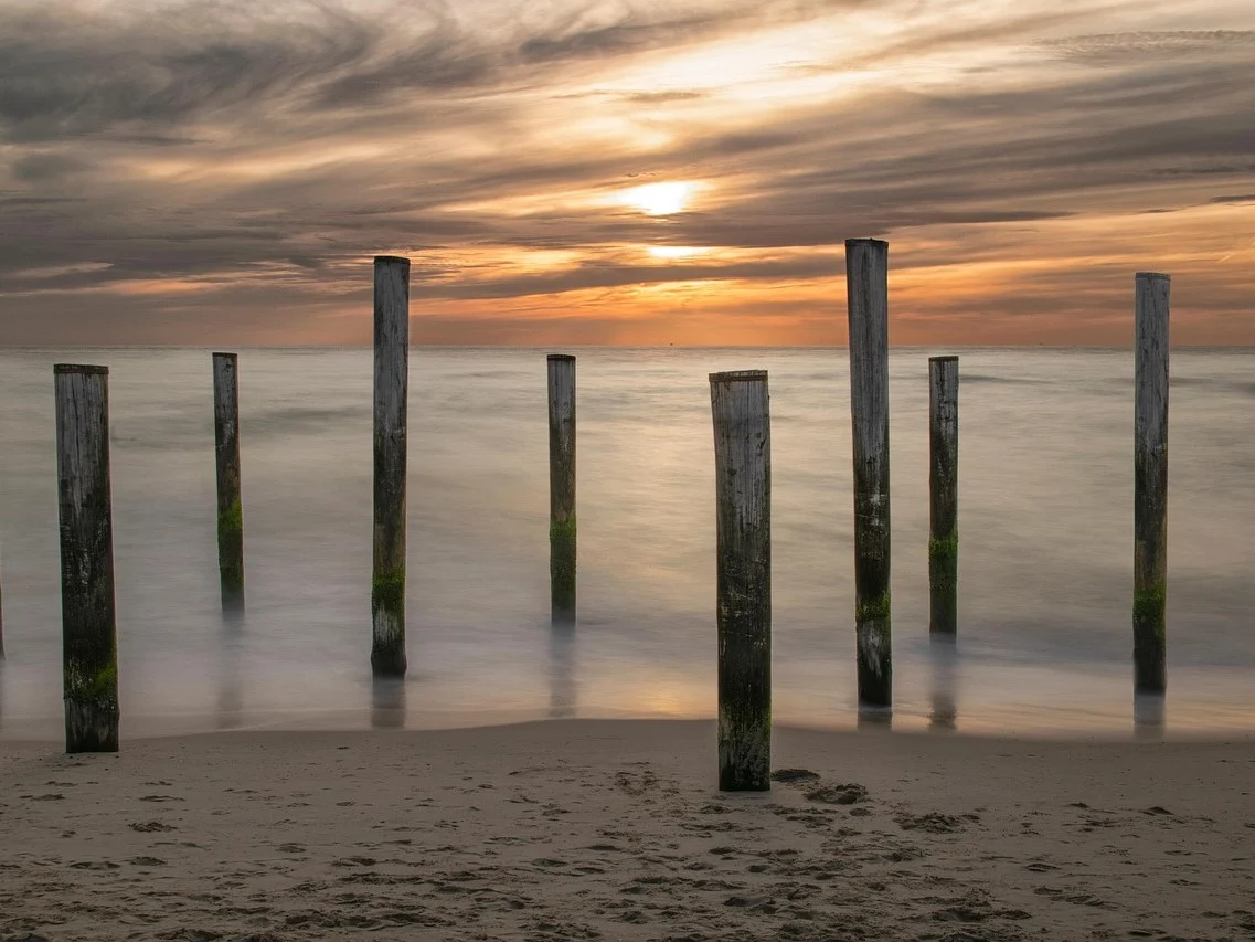 strand zee palen zonsondergang